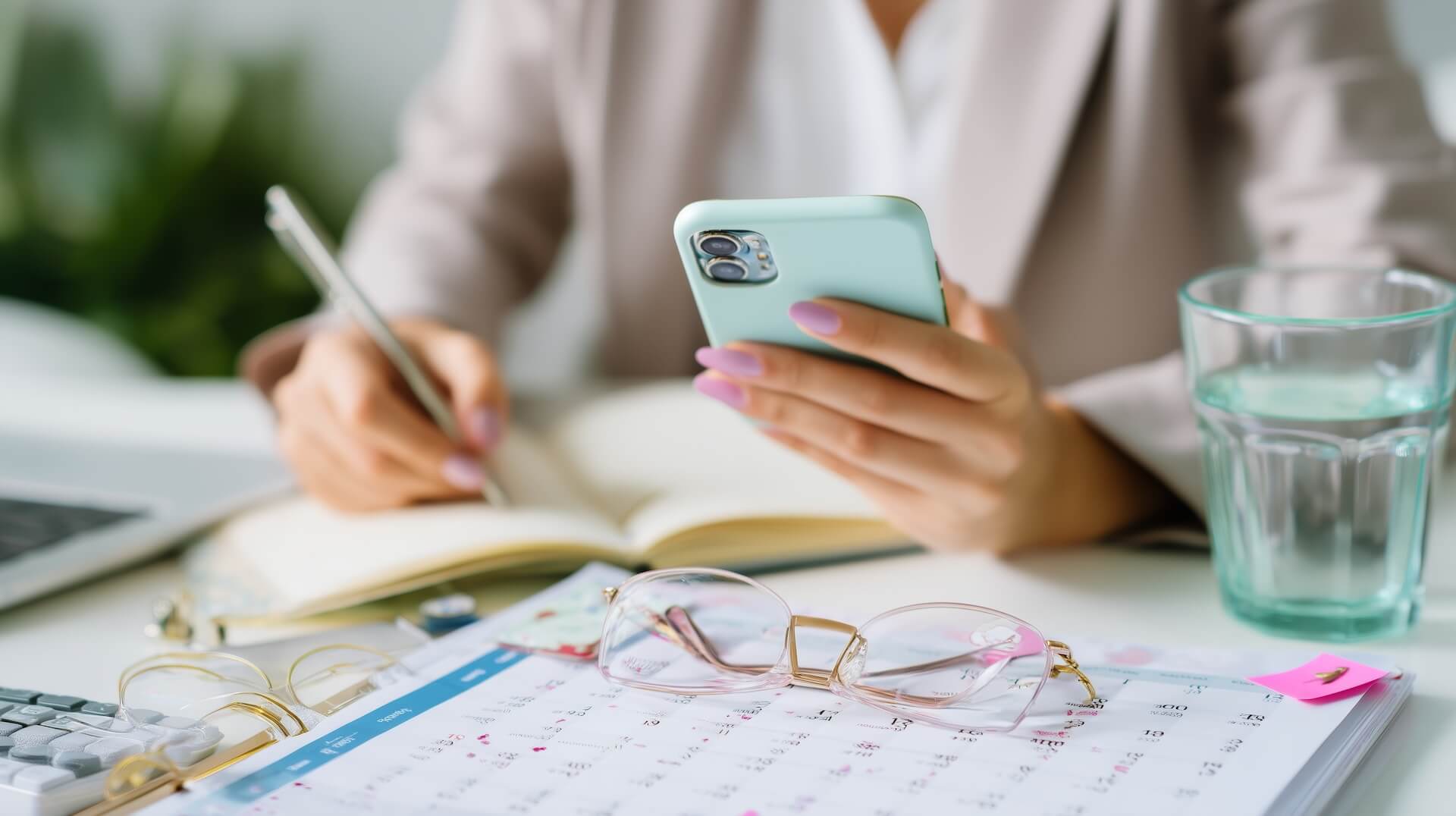 Business owner checking appointment messages while working from a paper calendar